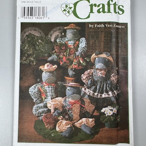 May include: Simplicity Crafts pattern 9584 featuring several fabric doll designs. The dolls are dressed in various outfits and hats, with a focus on craft projects. The pattern includes the text "ONE SIZE" and "by Faith Van Zanten."