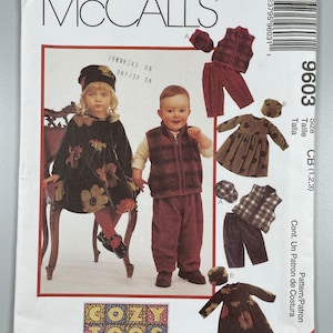 May include: A McCall's sewing pattern for children's clothing. The pattern is for a cozy, casual outfit for a baby or toddler. The pattern includes a dress, a vest, pants, and a hat. The pattern is called "Cozy Togs" and is size CB (1, 2, 3).