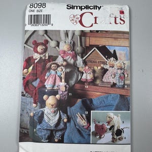 May include: Simplicity Crafts pattern featuring various handmade doll designs. The cover displays a variety of fabric dolls, including bears, bunnies, and other figures. The pattern number is 8098, and it is one size.