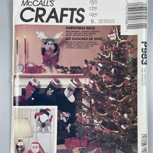 May include: A McCall's Crafts pattern for Christmas Bells. The pattern includes instructions for making ornaments, stockings, door knob covers, a tree skirt, wall-hanging wreath, and a greeting card holder. The pattern is called "Christmas Bells" and "Les Cloches de Noel".