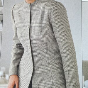 May include: A grey and white checked blazer with a stand-up collar and button fastening.