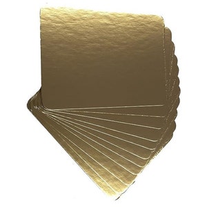 May include: A stack of 12 gold round cake boards. The boards are made of cardboard and have a scalloped edge.