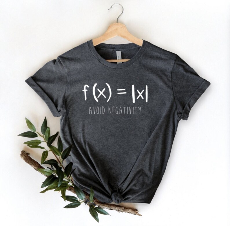 May include: A dark gray t-shirt with white text that reads "f(x) = |x| AVOID NEGATIVITY".