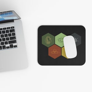 May include: Black rectangular mousepad with a white mouse and a laptop in the background. The mousepad features a design of five colored hexagonal shapes with various line art illustrations. The mouse is white.