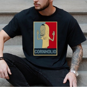 May include: A black t-shirt with a graphic of a cartoon character with the text "Cornholio" printed on the bottom.