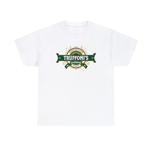 Può includere: T-shirt bianco con logo verde e oro di Truffoni's Steakhouse. Il logo recita "Premium Sloppy Steaks" e "Since 1985 New York, NY". Il design è centrato sul petto.