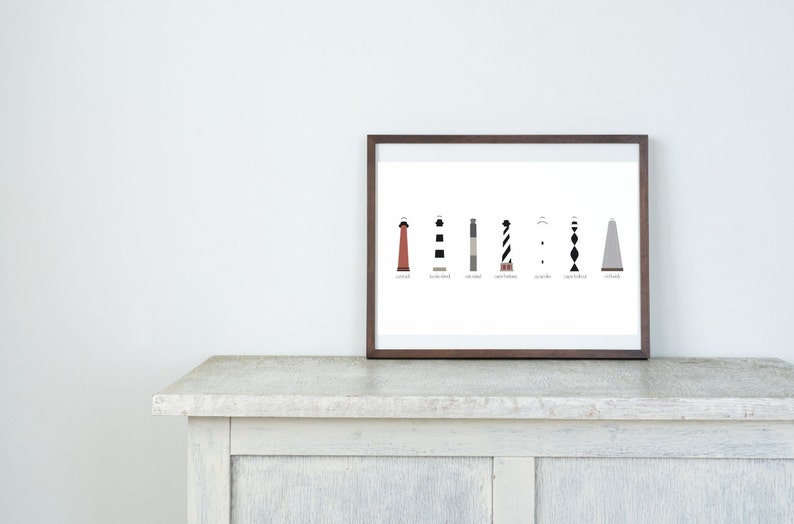 May include: A framed print featuring a black and white illustration of eight lighthouses with their names listed below each one.