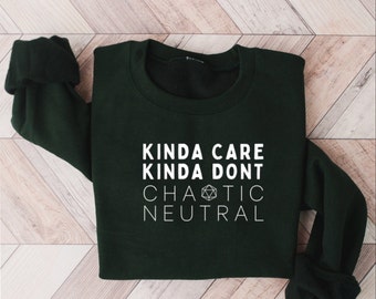 May include: A dark green sweatshirt with white text that reads "Kinda Care Kinda Don't Chaotic Neutral" and a white 20-sided die graphic.
