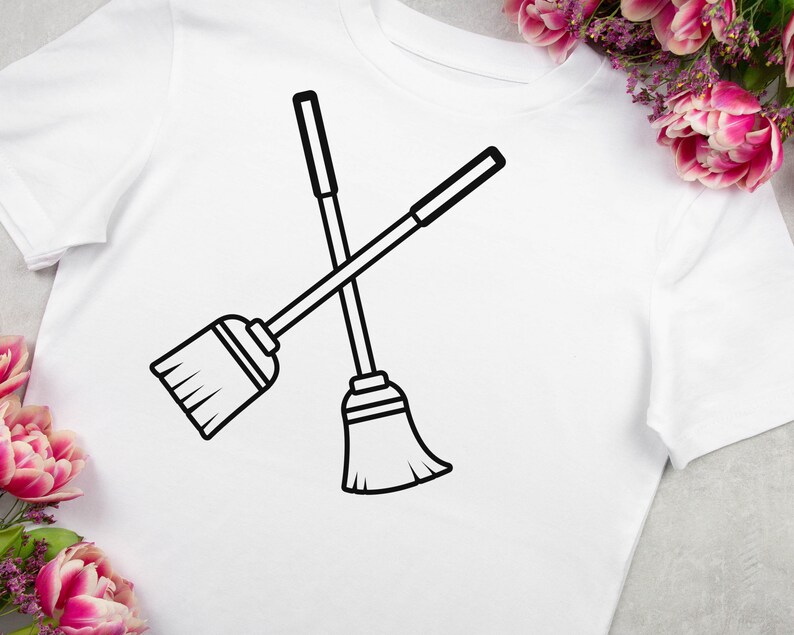 May include: A black and white line drawing of two crossed brooms on a white t-shirt.