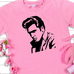 May include: Pink t-shirt with a black silhouette of Elvis Presley on the front.