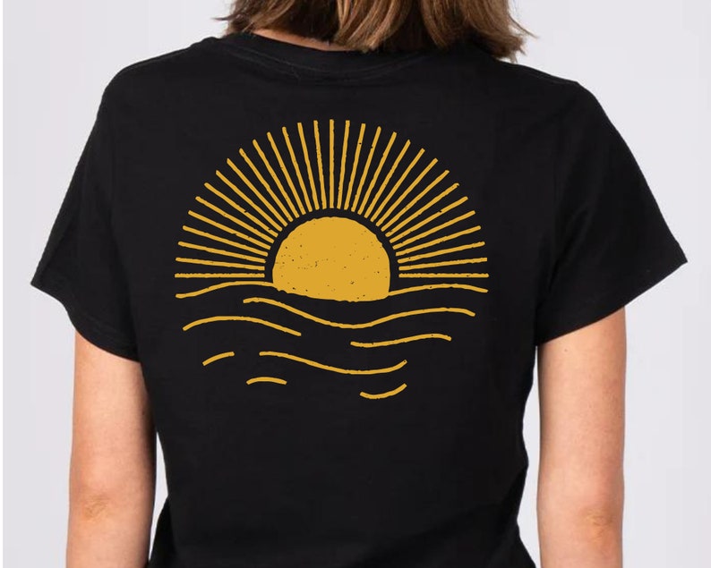May include: Black t-shirt with a yellow sun setting over the ocean graphic on the back.