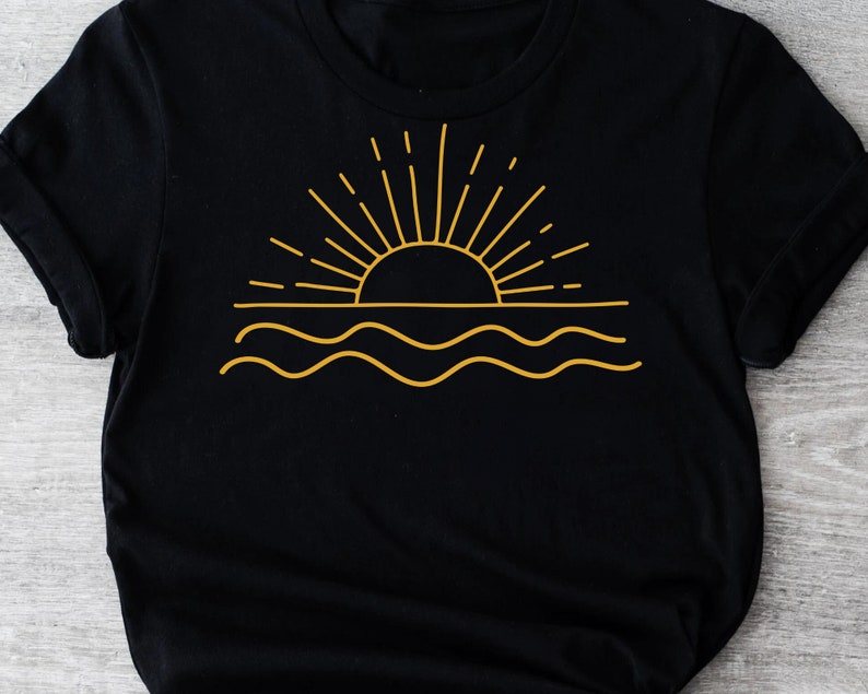 May include: Black t-shirt with a gold outline of a sun setting over wavy water.