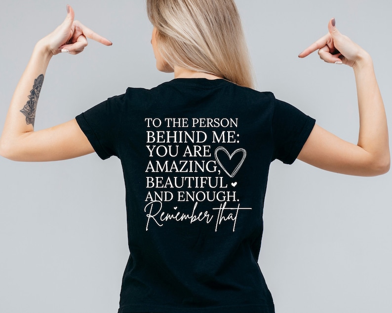 K&ouml;nnte beinhalten: Schwarzes T-Shirt mit wei&szlig;em Text, der lautet: "An die Person hinter mir: Du bist fantastisch, wundersch&ouml;n und genug. Denk daran."