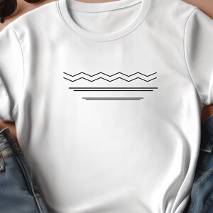 May include: White t-shirt with a black geometric design of a wavy line and two straight lines.