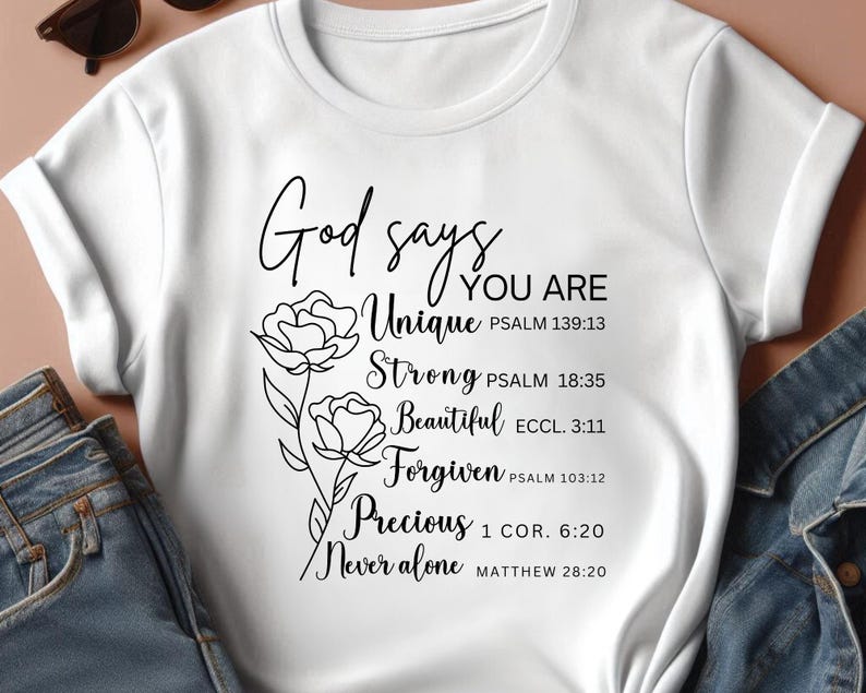 May include: White t-shirt with black text and a floral design. The text reads "God says you are Unique, Strong, Beautiful, Forgiven, Precious, Never alone" with corresponding bible verses.