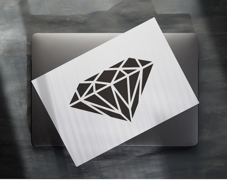 May include: A black diamond shape graphic on a white background. The graphic is on a laptop.