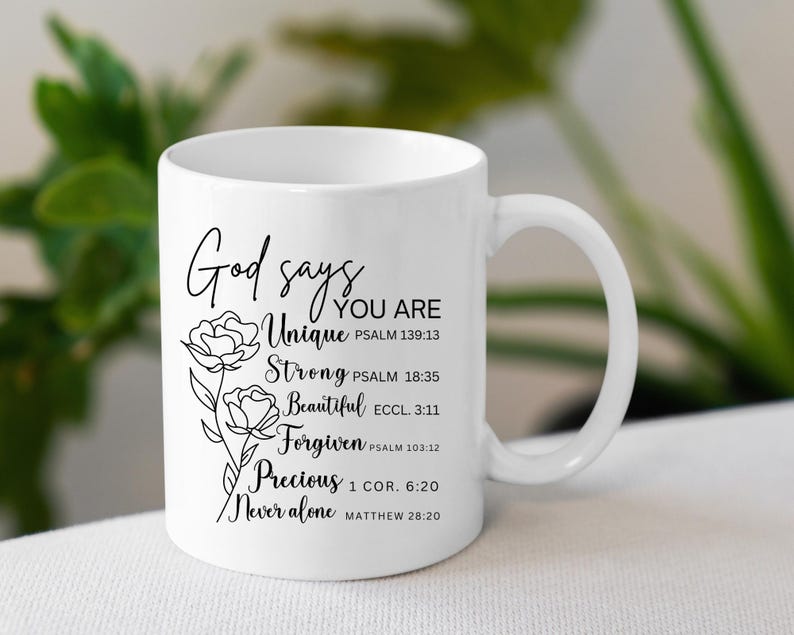 May include: White ceramic coffee mug with a black design that reads "God says you are Unique, Strong, Beautiful, Forgiven, Precious, Never alone" with bible verses listed below each word.