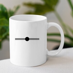 May include: White ceramic mug with a black circle and two horizontal lines on the front.
