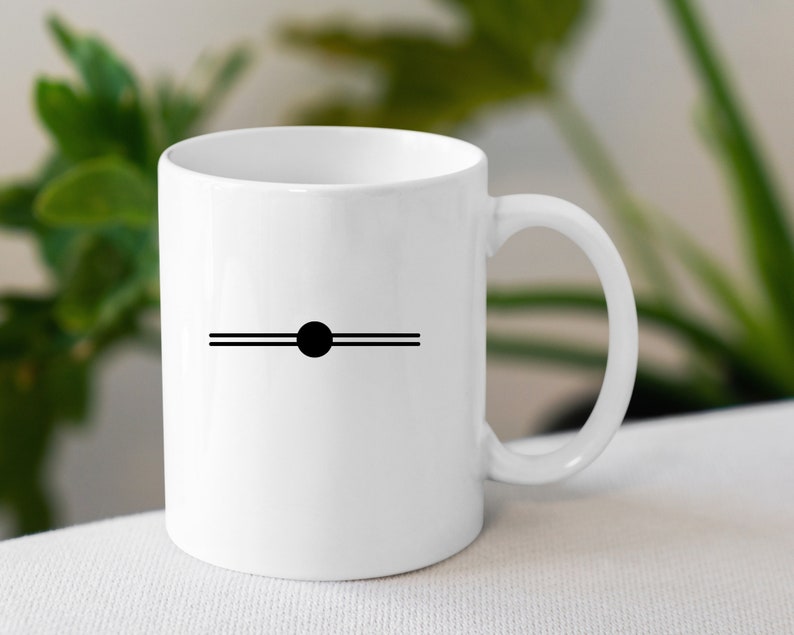 May include: White ceramic mug with a black circle and two horizontal lines on the front.