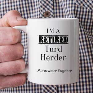 May include: White coffee mug with black text that reads "I'm a Retired Turd Herder - Wastewater Engineer".