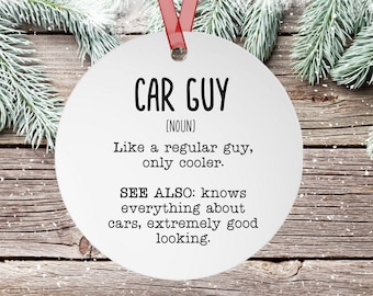 Może przedstawiać: Biała okrągła ozdoba z napisem "CAR GUY" czarnymi literami. Tekst "[NOUN]" znajduje się pod tytułem. Tekst "Like a regular guy, only cooler." znajduje się pod rzeczownikiem. Tekst "SEE ALSO: knows everything about cars, extremely good looking." znajduje się pod poprzednim tekstem.