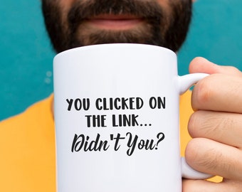 May include: White ceramic coffee mug with black text that reads "You clicked on the link... Didn't you?"
