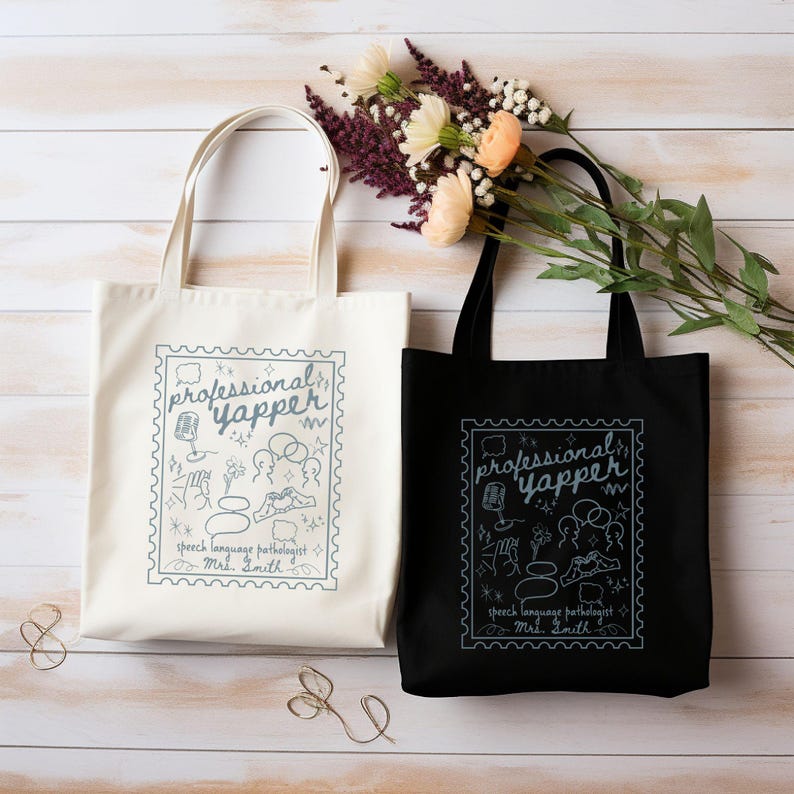 May include: Two tote bags, one cream and one black, with the text "professional yapper" in a stamp-like design. The design includes speech-related icons and the text "speech language pathologist Mrs. Smith". The bags have long handles.