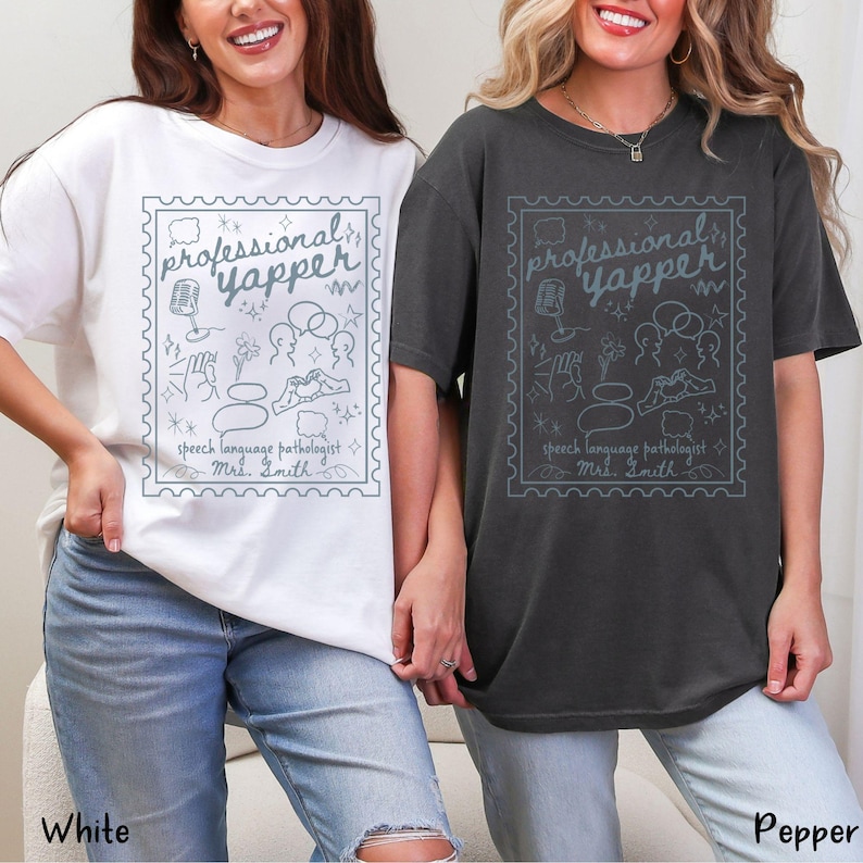 以下が含まれることがあります： 白とペッパー色の2枚のTシャツ。それぞれに、水色の切手のようなデザインが施されています。デザインには、「professional yapper」と「speech language pathologist Mrs. Smith」の文字と、さまざまなスピーチ関連のイラストが含まれています。