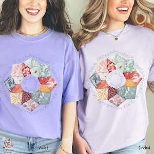 May include: Two women wearing purple t-shirts with a floral design and the text "I still like to play with blocks". The shirts are available in two colors: violet and orchid.