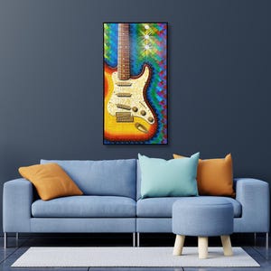 Puede incluir: Una impresi&oacute;n de arte mural rectangular que presenta una guitarra el&eacute;ctrica vibrante y multicolor con acabado sunburst, un golpeador de perloide blanco y tres pastillas, sobre un fondo din&aacute;mico y texturizado de pinceladas azules, verdes y rojas.