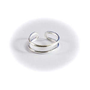 May include: A silver double-band ring with a simple design.