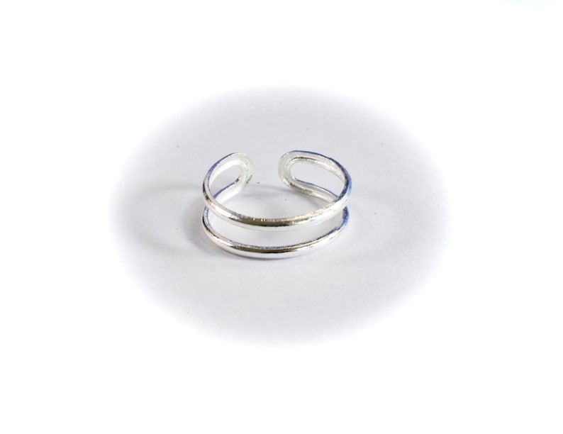 May include: A silver double-band ring with a simple design.