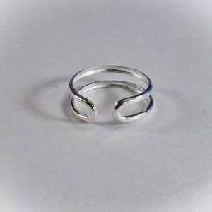 May include: A silver double band ring with a simple design.