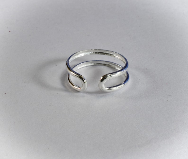May include: A silver double band ring with a simple design.