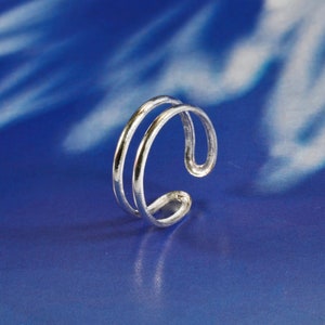 May include: A silver ring with a double band design. The ring is simple and elegant.