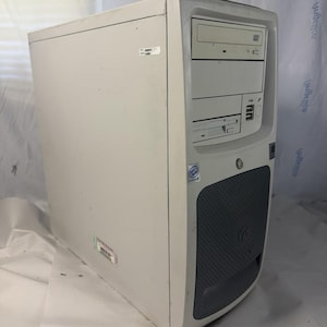 May include: A beige tower computer case featuring a top optical disc drive, a middle floppy disk drive, and two front-facing USB ports. The lower section of the front panel has a dark grey textured grille, and an Intel processor sticker is visible.