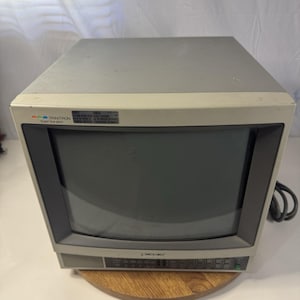 Puede incluir: Un monitor CRT Sony Trinitron Super Fine Pitch de color beige con un marco de pantalla gris oscuro. El panel frontal cuenta con una serie de botones de control y un interruptor de encendido. Una pequeña etiqueta está en la esquina superior.