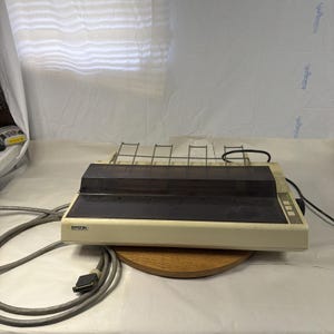 May include: A set of three ceramic mugs with a speckled, matte finish. The mugs are in shades of cream, light gray, and dark gray. Each mug has a simple, minimalist design and a rounded handle.