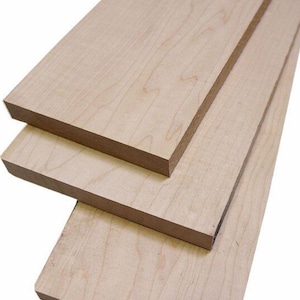 May include: Three pieces of unfinished maple wood. The wood is light brown with a natural grain pattern. The wood is stacked on top of each other.