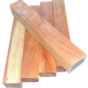 May include: Four pieces of unfinished wood, each with a rectangular shape and a smooth, light brown surface. The wood is arranged in a stack, with the largest piece on top.