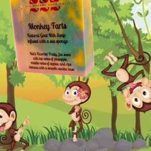 Op de afbeelding: Een kleurrijke zeep van "Monkey Farts" natuurlijke geitenmelk met tekst. De zeep is doordrenkt met een zeespons en heeft een fruitige geur. De achtergrond toont cartoonapen in een jungle.