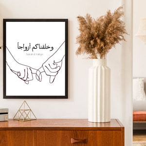 May include: Black and white line art print of two hands holding each other with the Arabic text "وخلقناكم أزواجا" and the names "Sarah & Yanuja" below.