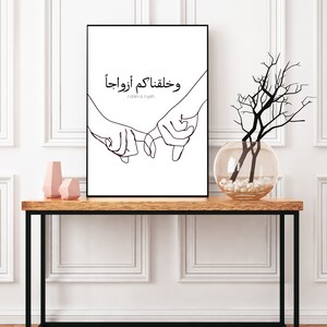 May include: Black and white line art print of two hands holding each other with the Arabic text "وَحَفِظْتُمْ أَوْرَادَنا" which translates to "And you have kept our prayers".