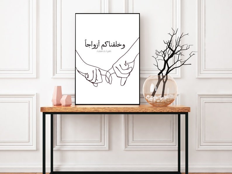 May include: Black and white line art print of two hands holding each other with the Arabic text "وَحَفِظْتُمْ أَوْرَادَنا" which translates to "And you have kept our prayers".