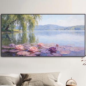 Könnte beinhalten: Ein gerahmtes Landschaftsgemälde zeigt eine ruhige See mit Seerosen. Das Kunstwerk zeigt eine Trauerweide, Berge in der Ferne und rosa und lila Seerosen, die auf dem Wasser schwimmen. Das Gemälde wird über einem Bett ausgestellt.