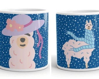 May include: Two white ceramic mugs with a blue background and white stars. One mug features a pink llama wearing a purple hat with pink flowers. The other mug features a pink llama wearing a blue scarf.