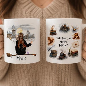 May include: Two white ceramic mugs featuring watercolor illustrations. The left mug shows a person with braided hair on a broomstick facing a castle with the name Maisie. The right mug displays magical icons and the text We love you Always, Maisie.