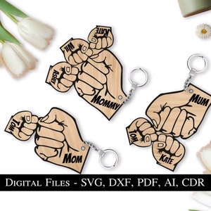 May include: A set of five wooden keychains with a hand-holding design. Each keychain features a different name, including "Mommy", "Ashly", "Will", "Kate", and "Tom".