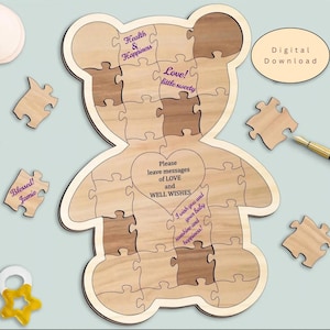 May include: A wooden bear-shaped jigsaw puzzle guest book with light and dark wood grain pieces. The centre features a heart with the text 'Please leave messages of LOVE and WELL WISHES'. Additional text includes 'Health & Happiness', 'Love! little sweety', 'Blessed! Jamie', and 'I wish you and your baby sunshine and happiness!'