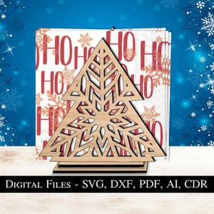 May include: A wooden Christmas tree-shaped napkin holder with a laser-cut design, holding napkins with a "HO HO HO" and snowflake pattern. The image also includes the text "DIGITAL FILES - SVG, DXF, PDF, AI, CDR".